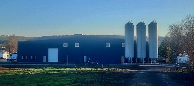 The Cascade Plastics plant in North Lewiston: a navy steel building with three tall resin silos beside it